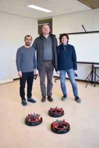 Dr Alkilabi (on the left), Dr Tuci (in the ), Prof Carleti (on the right) in the robotics lab with 3 robots of the robotic choral